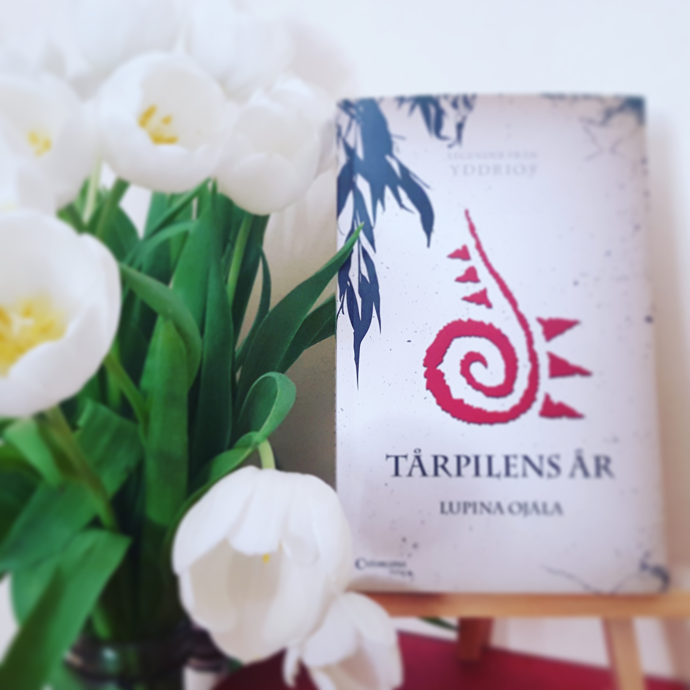 Boken Tårpilens år av Lupina Ojala och en bukett vita tulpaner.