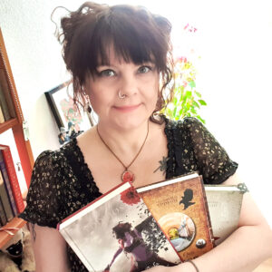Författaren Lupina Ojala med tre av sina fantasyromaner